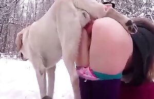 Một người phụ nữ đang quan hệ tình dục với một con chó trong thời tiết tuyết rơi